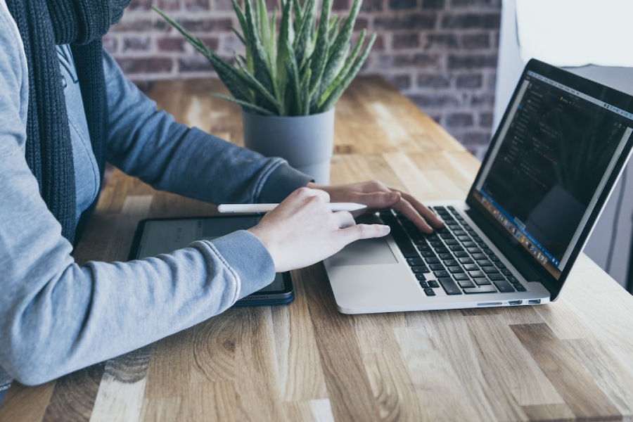 Professional using laptop and tablet device to create a pyramid chart